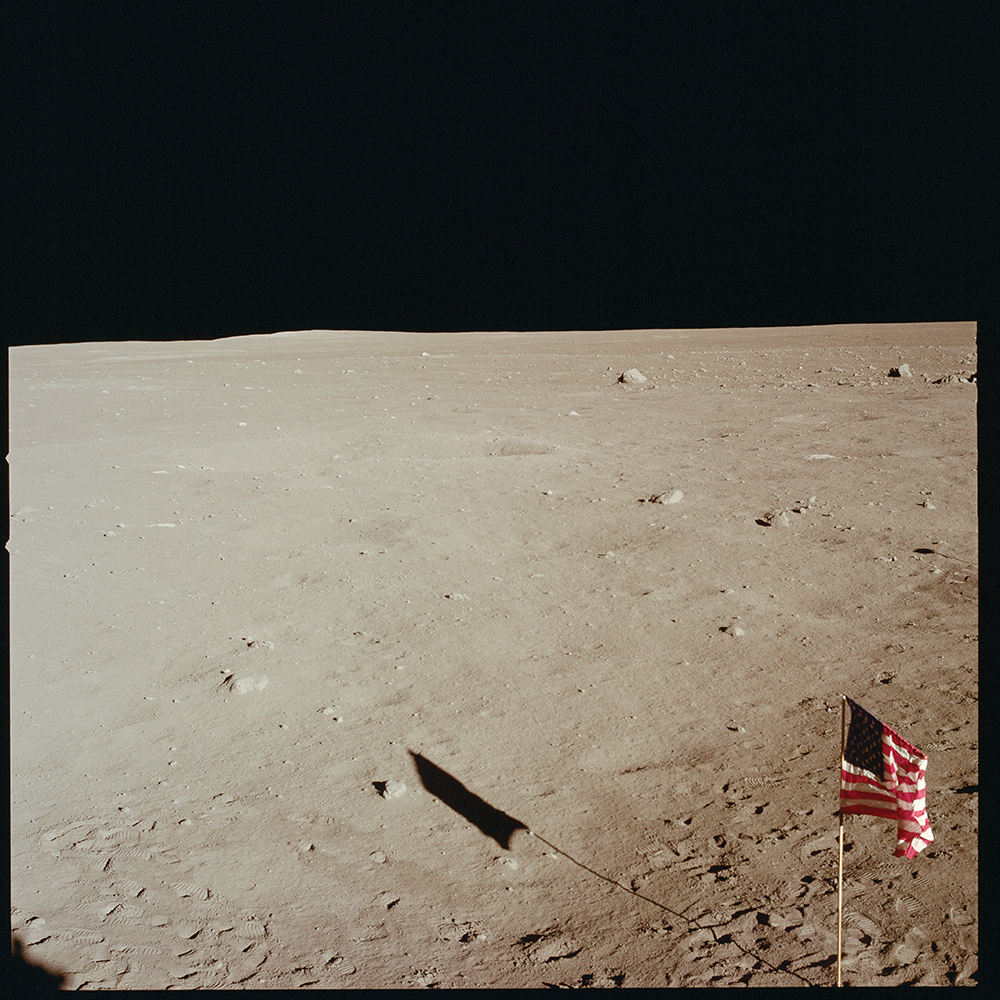 Tranquility Base and flag from the window of the Lunar Module Eagle. Taken with the Intra-vehicular (IVA) Hasselblad camera, which lacks a Réseau plate. Photo by Edwin Buzz Aldrin. [Apollo 11] From 