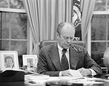 President Ford Smokes Pipe at Desk in Oval Office Photo Print