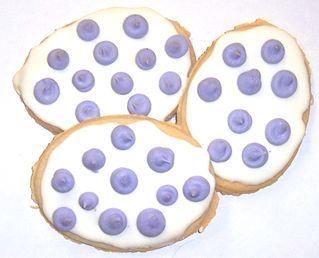 1 Pound White Iced Egg Shaped Cookies with Lavender Polka-Dots in a Decorative Tray with Krinkle