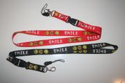 2 HAPPY SMILEY FLACE LANYARDS KEYCHAINS PASSHOLDERS ... CHOOSE BETWEEN RED & BLACK .. NEW