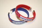 2 NORTH KOREA COUNTRY FLAG FLEXIBLE NYLON BRACELETS ... CHOOSE BETWEEN RED AND BLUE ... NEW