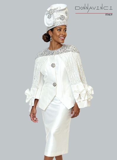 Donna Vinci Couture <br> (Spring/Summer 2026) <br> DV12268 <br> <br> WHITE <br> 8 10 12 14 16 18 20 22 24<br> <br> 2pc. Jacket & Skirt Set <br> Virtual Silk Look Fabric Designed With Exclusive Lace Cape, Trimmed With Silver Sequins & Beautiful Buttons