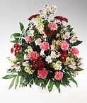 Abundant mixed flower in a handled basket sympathy