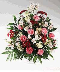 Abundant mixed flower in a handled basket sympathy