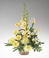 A basket arrangement of yellow and white flowers.