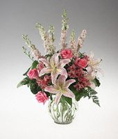A clear vase arrangement of pink and white flowers sympathy