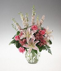 A clear vase arrangement of pink and white flowers sympathy
