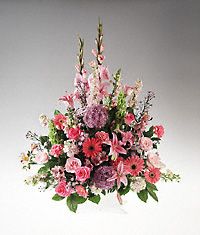 A handled basket filled with pink and lavender flowers sympathy
