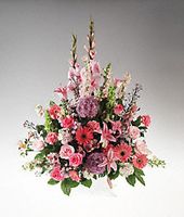 A handled basket filled with pink and lavender flowers sympathy