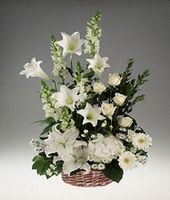 Basket arrangement of mixed white flowers.