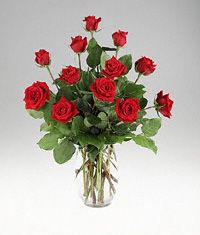 One dozen red roses in a clear vase.