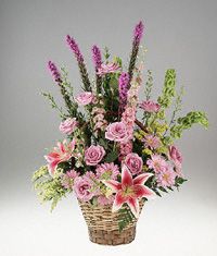 Pink and lavender flowers in a handled basket.