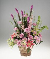 Pink and lavender flowers in a handled basket.