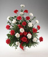 Red and white carnations in a handled basket.
