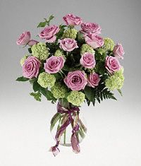 Roses and viburnum in a clear vase.
