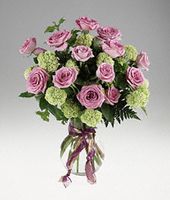 Roses and viburnum in a clear vase.